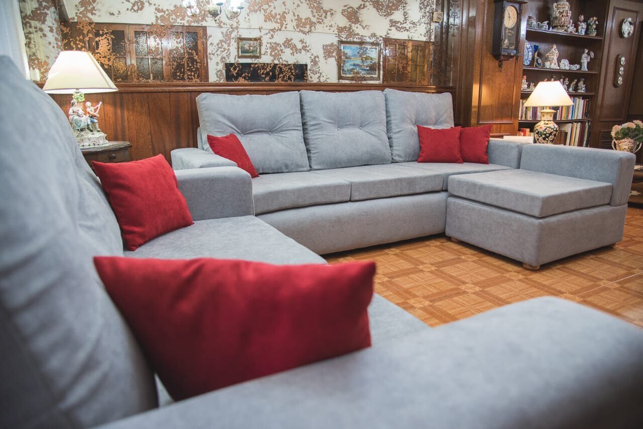 Sofá gris con almohadones rojos